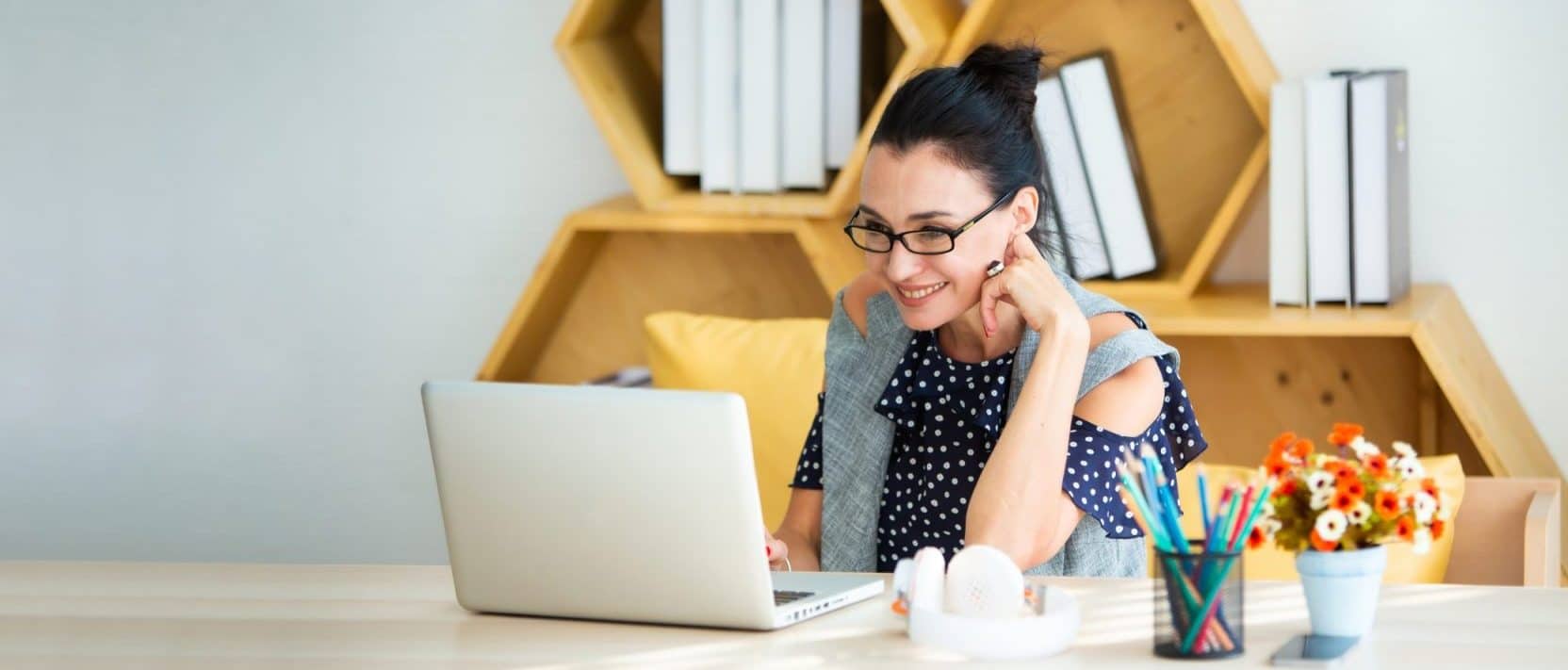 A business woman sitting at a desk looking at a laptop, representing how one can benefit from calling a Portland divorce attorney.