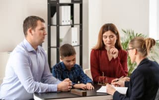 Divorced parents with their son visiting lawyer. Concept of child support