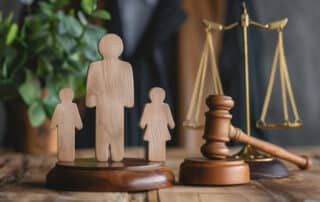 Maine Involuntary Termination of Parental Rights portrayed by wooden family figurine cut outs next to the scales of justice.